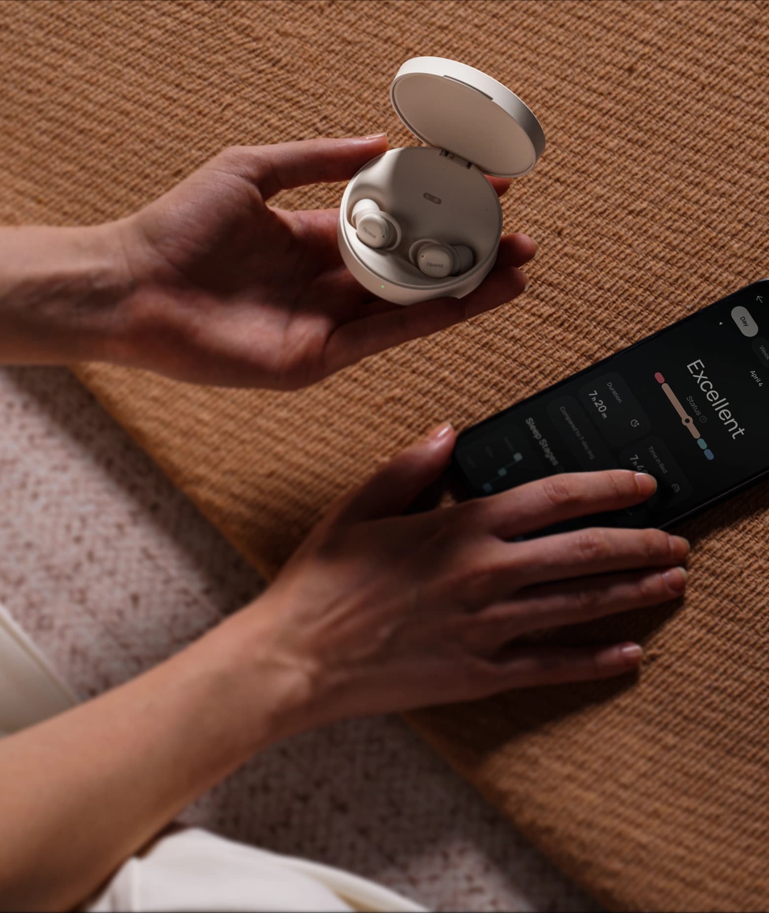 SomniPods 3 earbuds in charging case on bed